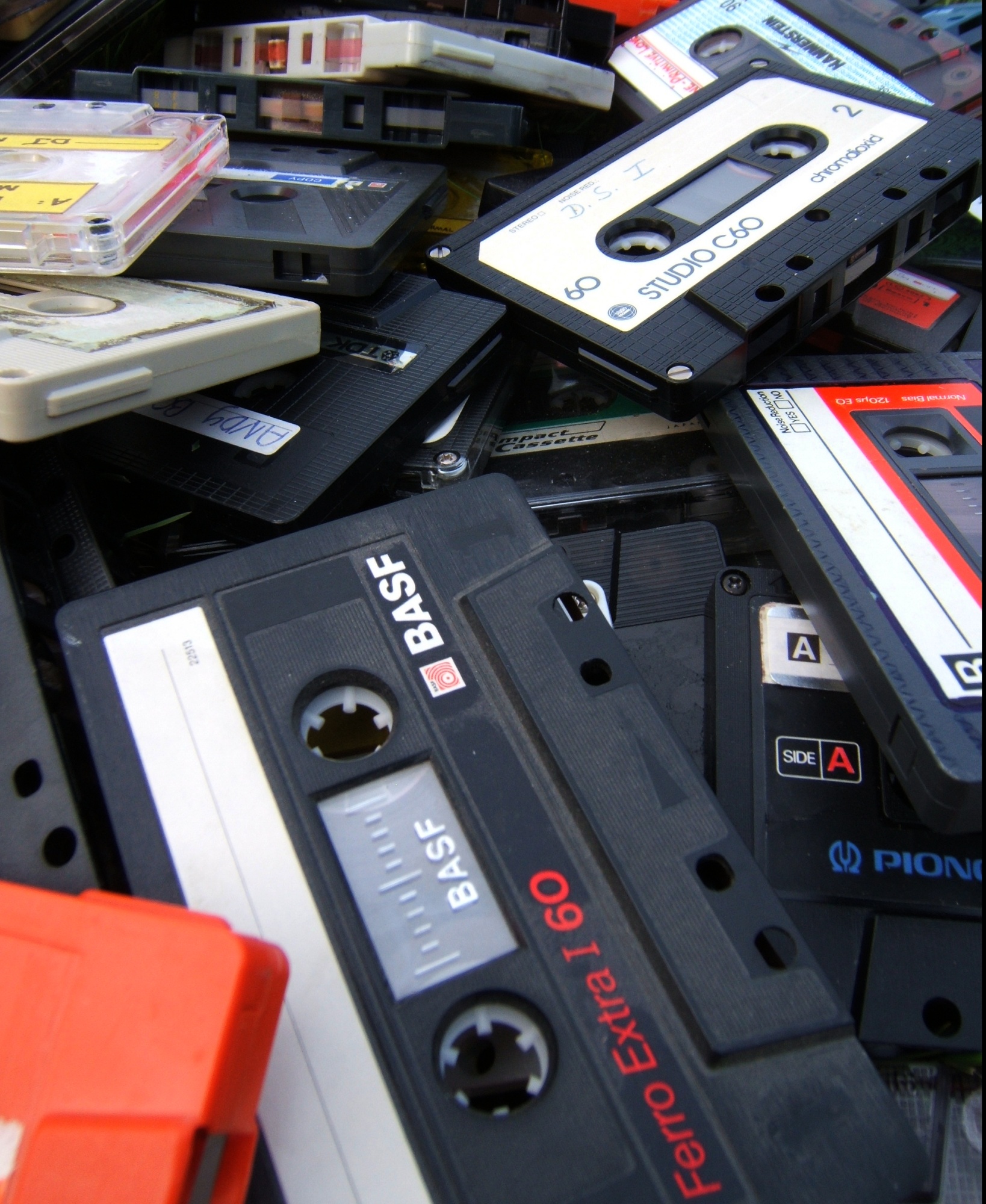 A colorful collection of audio cassettes with printed and handwritten labels